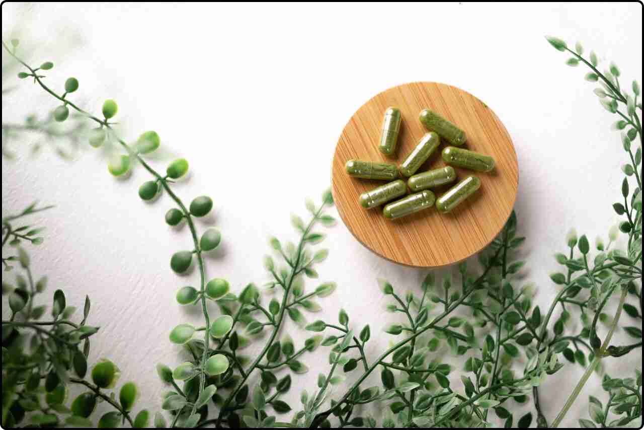 Healthy superfood capsule with fresh leaves in a minimalistic setting.